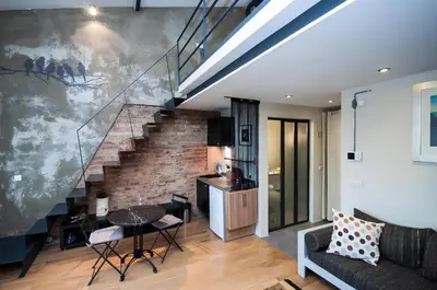 a living room with a staircase and a table at Taksim Galata Tower, Rooms Galata Historical Hotel in Istanbul