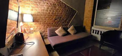 a living room with a couch and a brick wall at Taksim Galata Tower, Rooms Galata Historical Hotel in Istanbul