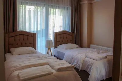 two twin beds in a room with a window at Sawsana Villalari in Sapanca