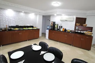 a dining room with a table and a kitchen at Lyon Hotel İstanbul in Istanbul