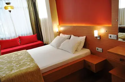 a hotel room with a bed and a red chair at Antique Hostel in Istanbul