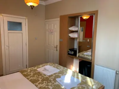 a small room with a bed and a mirror at Antique Hostel in Istanbul