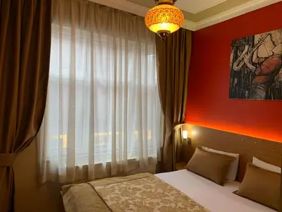 a bedroom with a bed and a window and a chandelier at Antique Hostel in Istanbul
