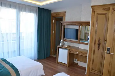 a hotel room with a bed and a desk with a television at Ahmet Efendi Konağı in Istanbul