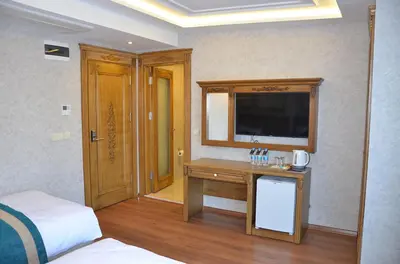 a bedroom with a bed and a desk with a television at Ahmet Efendi Konağı in Istanbul