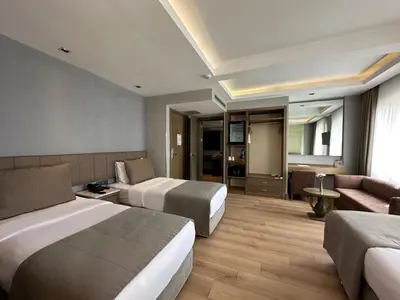 a hotel room with two beds and a couch at AHC Grand Bazaar Hotel in Istanbul