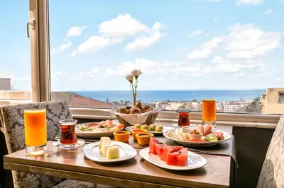 a table with plates of food and a view of the ocean at AHC Grand Bazaar Hotel in Istanbul