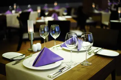 a table with wine glasses and purple napkins on it at Crowne Plaza Istanbul Harbiye by IHG in Istanbul