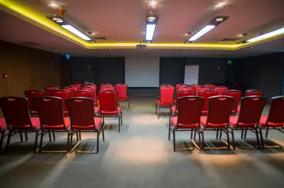 a conference room with red chairs and a screen at Crowne Plaza Istanbul Harbiye by IHG in Istanbul