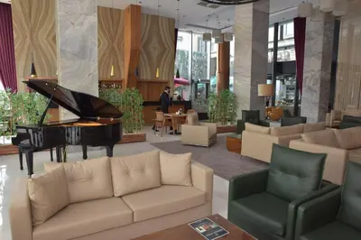a living room with a piano and couches at Crowne Plaza Istanbul Harbiye by IHG in Istanbul