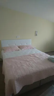 a white bed with pink sheets and pink pillows at Kumbaz Pansiyon in Sapanca