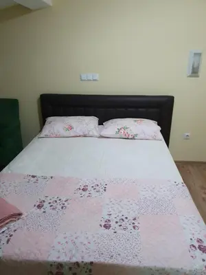 a bed with a pink and white quilt on it at Kumbaz Pansiyon in Sapanca