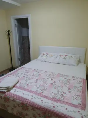 a bed with a pink and white quilt on it at Kumbaz Pansiyon in Sapanca