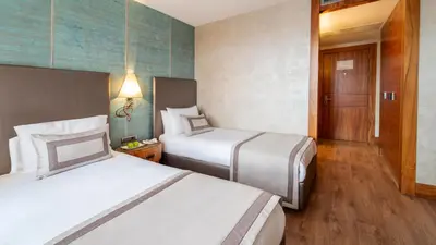 a hotel room with two beds and a hallway at Biz Cevahir Hotel Sultanahmet in Istanbul