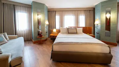a hotel room with a large bed and a couch at Biz Cevahir Hotel Sultanahmet in Istanbul