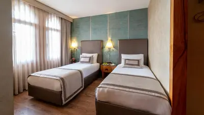 a hotel room with two beds and a window at Biz Cevahir Hotel Sultanahmet in Istanbul