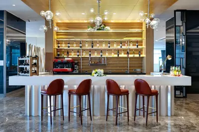 a kitchen with a bar with red stools at TRYP by Wyndham Istanbul Basın Ekspres in Istanbul