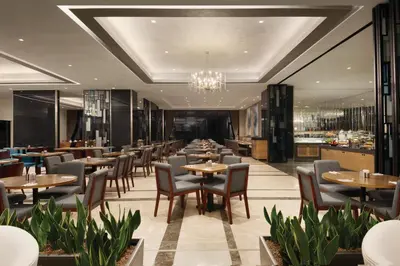 a restaurant with tables and chairs and a chandelier at TRYP by Wyndham Istanbul Basın Ekspres in Istanbul