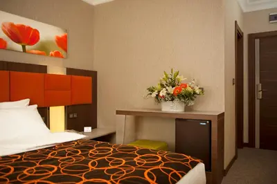 a hotel room with a bed and flowers on a desk at Birbey Hotel in Istanbul