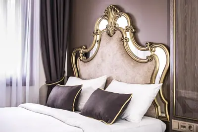 a bed with a gold framed headboard with pillows at Dara Old City Hotel in Istanbul