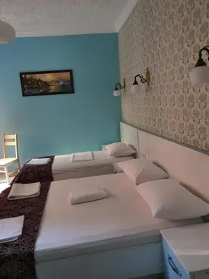 a room with three beds and a blue wall at Tulip Guesthouse in Istanbul