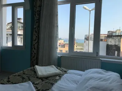 a bed in a room with a large window at Tulip Guesthouse in Istanbul