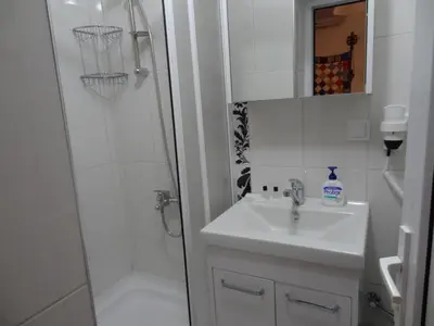 a white bathroom with a sink and a shower at Tulip Guesthouse in Istanbul