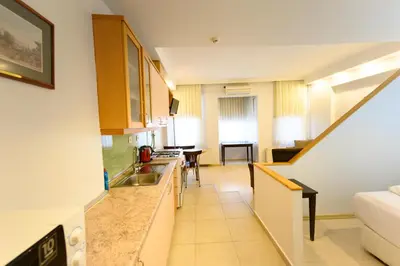 a kitchen with a sink and a living room at Entes Apart in Istanbul