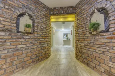 a hallway with a brick wall with two windows at Agva Greenline Guesthouse (Adult Only +12) in Agva