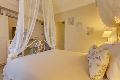 a bedroom with a white bed with curtains at Agva Greenline Guesthouse (Adult Only +12) in Agva