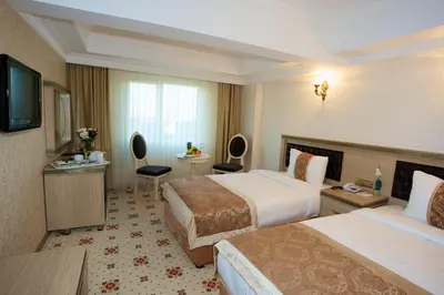 a hotel room with two beds and a television at Marmaray Hotel in Istanbul