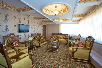 a living room with couches and tables and a television at Marmaray Hotel in Istanbul