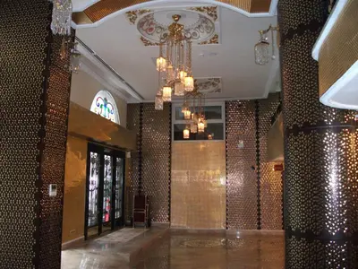 a lobby with a chandelier and a wall of tiles at Marmaray Hotel in Istanbul