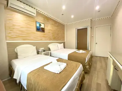 a hotel room with two beds and a television at Grand Oral Hotel in Istanbul