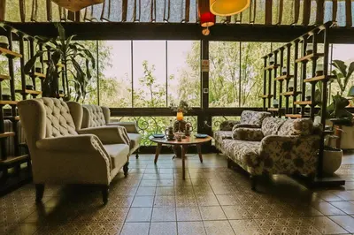 a living room with couches and a table and a large window at Wineport Lodge Agva Riverside Hotel & Winery in Agva
