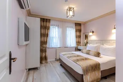 a hotel room with a large bed and a television at Agora Guesthouse in Istanbul