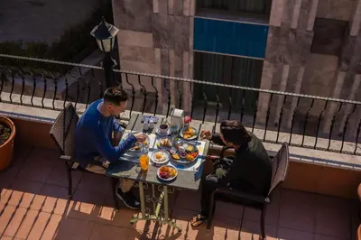 two men sitting at a table eating food at Agora Guesthouse in Istanbul