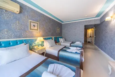 a hotel room with two beds and a chair at Viva Deluxe Hotel in Istanbul