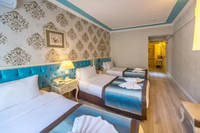 a hotel room with two beds and a table at Viva Deluxe Hotel in Istanbul