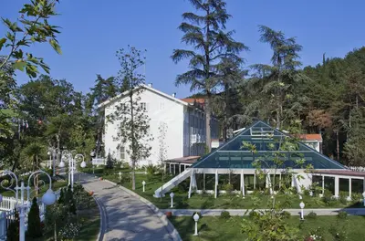 a building with a glass roof in a park at Limak Yalova Thermal Boutique Hotel in Gokcedere