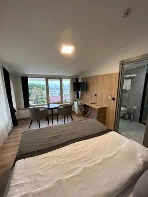 a bedroom with a bed and a table and chairs at Pendik Marine Hotel in Istanbul