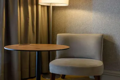 a table and a chair next to a table and a lamp at Ramada by Wyndham Istanbul Grand Bazaar in Istanbul