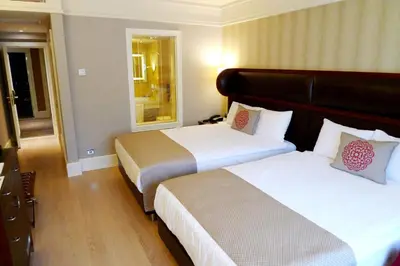 a hotel room with two beds and a mirror at Titanic Comfort Sisli in Istanbul