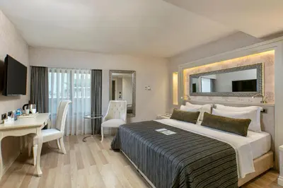 a hotel room with a large bed and a desk at Limak Eurasia Luxury Hotel in Istanbul