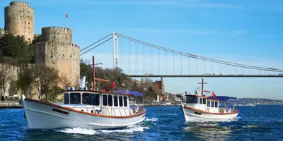 two boats in the water with a bridge in the background at Sparkle Hotel in Istanbul