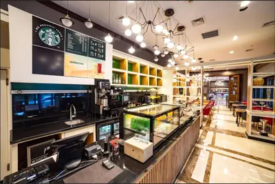 a coffee shop with a counter and a bar at Ramada by Wyndham Istanbul Alibeykoy in Istanbul