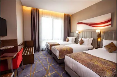 a hotel room with two beds and a desk at Ramada by Wyndham Istanbul Alibeykoy in Istanbul