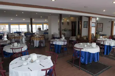 a restaurant with tables and chairs with white and blue tablecloths at Hali Hotel in Istanbul