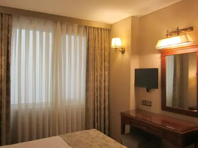 a hotel room with a bed and a mirror and a window at Hotel Perula & SPA in Istanbul