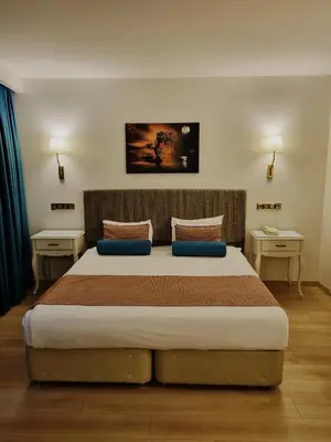 a bedroom with a large bed with blue pillows at Taximtown Hotel in Istanbul